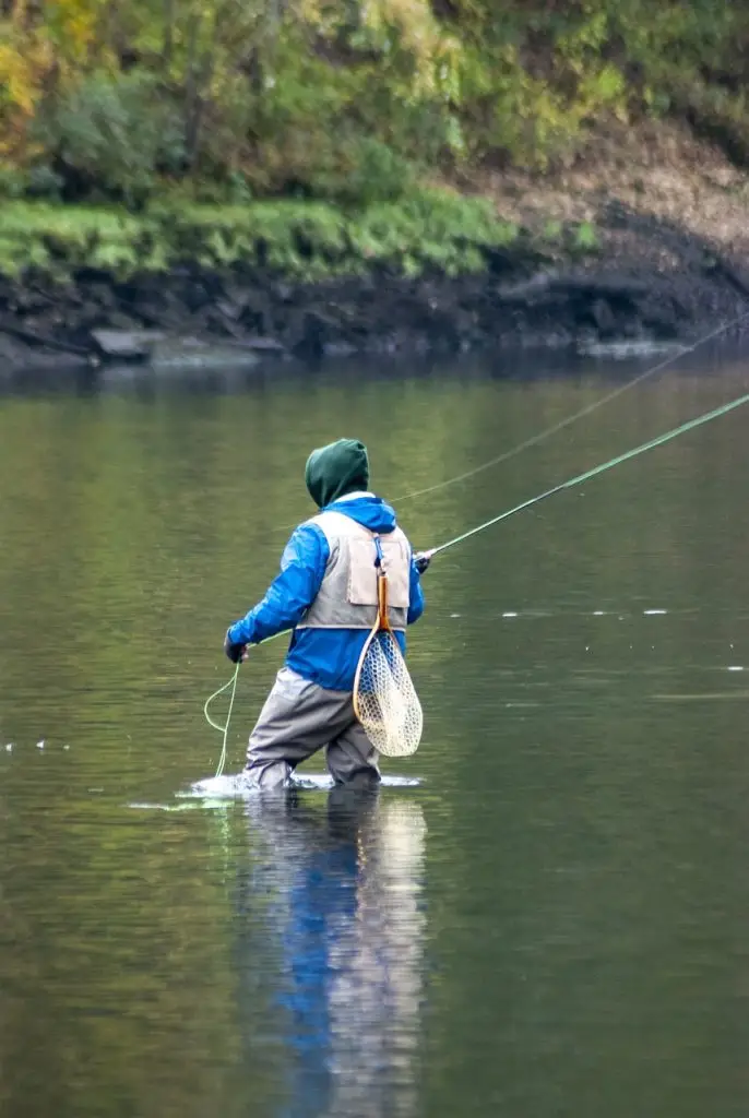pêcheur à la mouche au milieu de l'eau