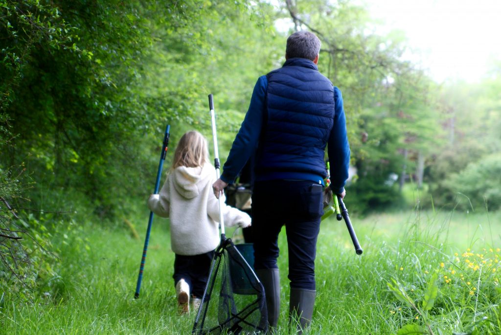 deux personnes, un enfant et un homme de dos avec canne à pêche
